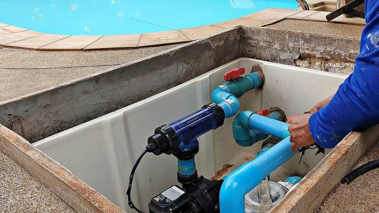 Equipo de cloración salina conectado a la bomba de una piscina en su arqueta técnica