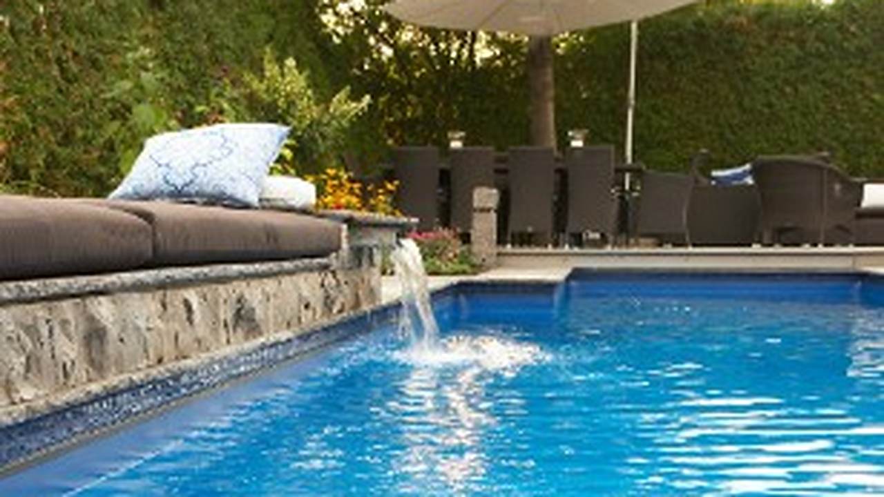 Piscina de obra con cascada y zona chill out en un jardín de Marbella