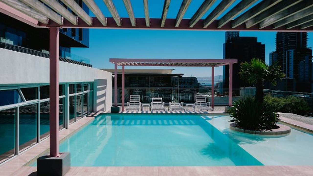 Piscina urbana con pérgola y solárium en una vivienda de Málaga capital