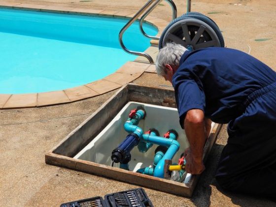 Técnico conectando el equipo de filtración y cloración de una piscina en Málaga